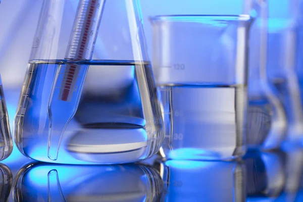 Laboratuvar konsepti. Mavi arka planda cam tüpler ve beherler.