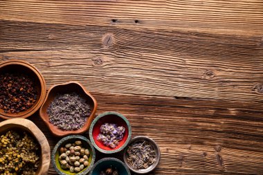 Doğal tıp geçmişi. Kâselerde çeşitli kuru otlar ve rustik ahşap masa üzerinde pirinç havan..