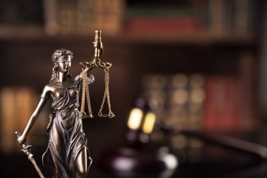 Hukuk teması. Yargıç odası. Hakimler tokmak, heykel ve kahverengi arka planda hukuk kitapları koleksiyonu..