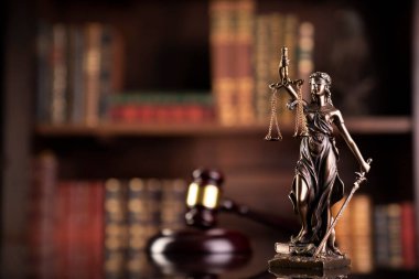 Hukuk teması. Yargıç odası. Hakimler tokmak, heykel ve kahverengi arka planda hukuk kitapları koleksiyonu..