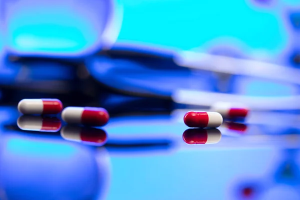 Global healthcare concept. Stethoscope and medicines. Blue table and background.