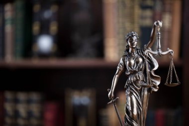 Hukuk kavramı. Avukatlık bürosu. Raftaki heykel hukuk kitaplarının arka planında.. 