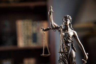 Hukuk kavramı. Avukatlık bürosu. Raftaki heykel hukuk kitaplarının arka planında.. 