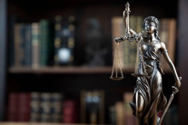 Hukuk kavramı. Avukatlık bürosu. Raftaki heykel hukuk kitaplarının arka planında.. 