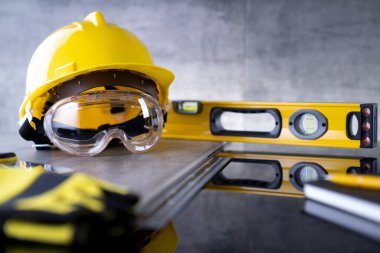 Müteahhit teması. Müteahhitin alet çantası: sarı başlık, karalama ve gri karo arka plandaki araçlar.