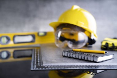 Müteahhit teması. Müteahhitin alet çantası: sarı başlık, karalama ve gri karo arka plandaki araçlar.