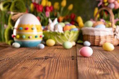 Paskalya teması. Paskalya yumurtaları. Renkli laleler. Paskalya sepetleri. Kırsal ahşap masa.. 