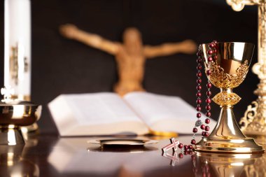 Dini bayram Paskalyası. Katolik sembolleri kompozisyonu. İsa figürü, Haç, Monstrance, Kutsal İncil, gri arka planda tespih ve altın kadeh.. 