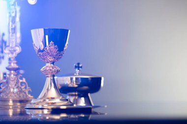 Din temalı Paskalya. Katolik sembolleri kompozisyonu. Haç, monarşi ve altın kadeh mavi arka planda.. 