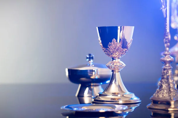 Religion theme  Easter. Catholic symbols composition. The Cross, monstrance  and golden chalice on blue background.