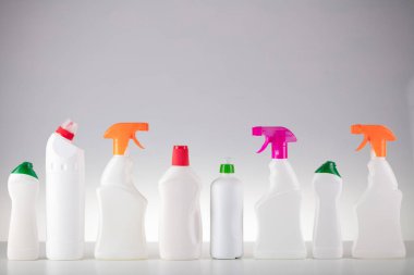 Ev ve ofis temizliği teması. Beyaz arka planda yapışkan sıvılar olan beyaz şişeler..