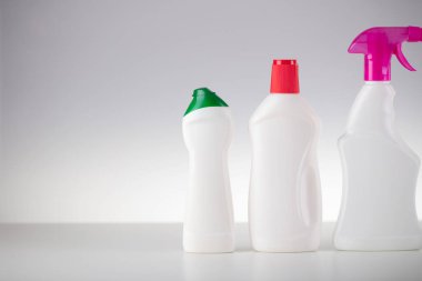 Ev ve ofis temizliği teması. Beyaz arka planda yapışkan sıvılar olan beyaz şişeler..