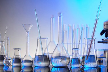 Coronavirus salgını teması. Hızlı covid testleri ve anti-covid aşısıyla ilgili bilimsel araştırma. Mavi arka planda mikroskop, deney tüpleri ve deney tüpleri..