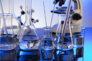 Coronavirus salgını teması. Hızlı covid testleri ve anti-covid aşısıyla ilgili bilimsel araştırma. Mavi arka planda mikroskop, deney tüpleri ve deney tüpleri..