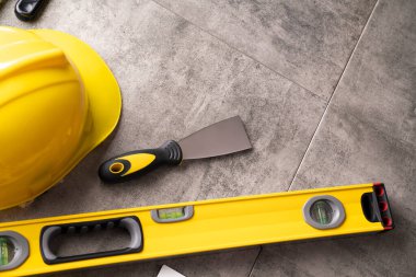 Müteahhit teması. Müteahhitin alet çantası: sarı başlık, karalama ve gri karo arka plandaki araçlar.
