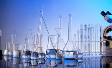 Laboratuvar araştırmaları. Mavi arka planda mikroskop, cam tüpler ve deney tüpleri..