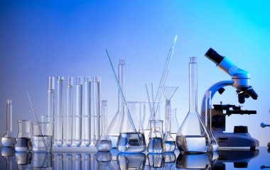 Laboratuvar araştırmaları. Mavi arka planda mikroskop, cam tüpler ve deney tüpleri..