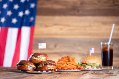 4 Temmuz kutlamaları. Amerikan bayrağı ve madalyaları. Köy ahşap masada hamburgerler.