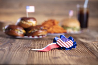 4 Temmuz kutlamaları. Amerikan bayrağı ve madalyaları. Köy ahşap masada hamburgerler.