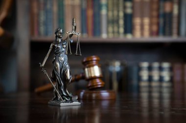 Hukuk teması. Yargıç odası. Kahverengi masanın üzerindeki tokmak ve tokmak. Kitaplıkta yasal kitap koleksiyonu.