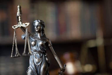 Hukuk teması. Yargıç odası. Kahverengi masanın üzerindeki tokmak ve tokmak. Kitaplıkta yasal kitap koleksiyonu.