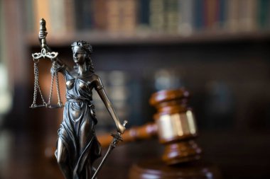 Hukuk teması. Yargıç odası. Kahverengi masanın üzerindeki tokmak ve tokmak. Kitaplıkta yasal kitap koleksiyonu.