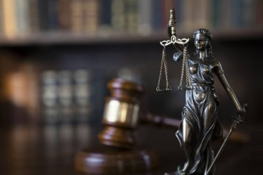 Hukuk teması. Yargıç odası. Kahverengi masanın üzerindeki tokmak ve tokmak. Kitaplıkta yasal kitap koleksiyonu.