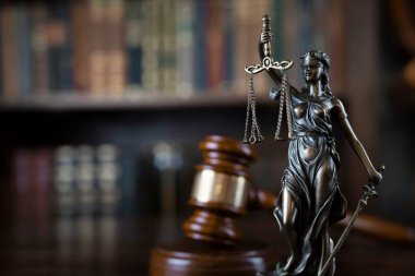 Hukuk teması. Yargıç odası. Kahverengi masanın üzerindeki tokmak ve tokmak. Kitaplıkta yasal kitap koleksiyonu.