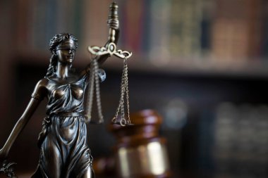 Hukuk teması. Yargıç odası. Kahverengi masanın üzerindeki tokmak ve tokmak. Kitaplıkta yasal kitap koleksiyonu.