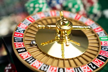 Kumarhane. Kumar oyunları teması. Kumarhanedeki rulet çarkı, zar ve poker fişleri yeşil masa gibiydi..