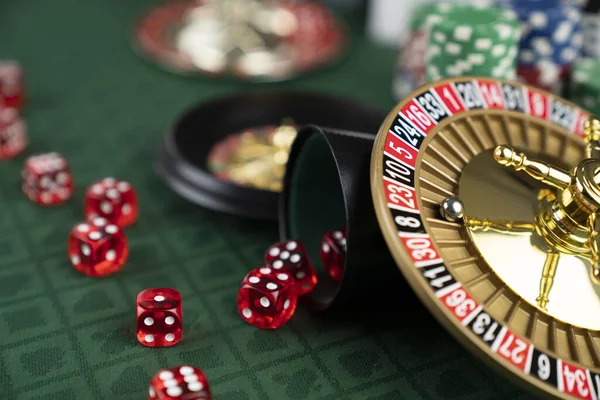卡西诺赌博游戏主题 赌场里的轮盘赌 骰子和扑克筹码都感觉到了绿色的桌子 — 图库照片
