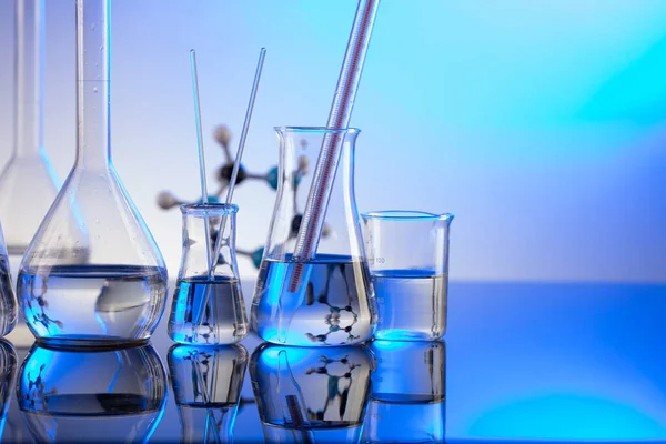 实验室调查 蓝色背景的玻璃管和烧杯 — 图库照片