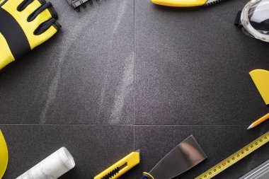 Müteahhit teması. Planlar, müteahhitin alet çantası, sarı başlık ve iftiralar. Gri karolar arka plan.