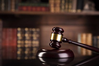 Hukuk teması. Yargıç odası. Gavel kahverengi masada. Kitaplıkta yasal kitap koleksiyonu.