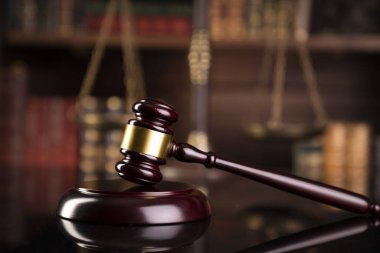 Hukuk teması. Yargıç odası. Gavel kahverengi masada. Kitaplıkta yasal kitap koleksiyonu.
