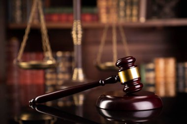 Hukuk teması. Yargıç odası. Gavel kahverengi masada. Kitaplıkta yasal kitap koleksiyonu.