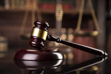 Hukuk teması. Yargıç odası. Gavel kahverengi masada. Kitaplıkta yasal kitap koleksiyonu.