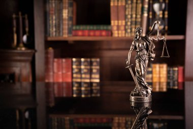 Hukuk teması. Yargıç odası. Gavel kahverengi masada. Kitaplıkta yasal kitap koleksiyonu.