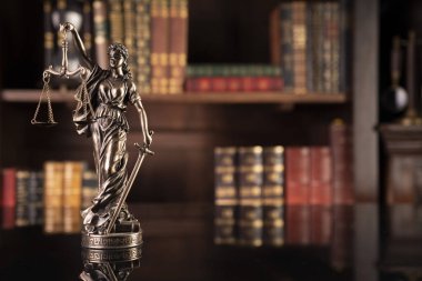 Hukuk teması. Yargıç odası. Gavel kahverengi masada. Kitaplıkta yasal kitap koleksiyonu.