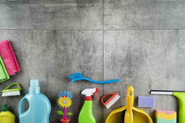 Sonbahar temizliği. Renkli şişeler, yapışkan sıvılar ve gri fayansların üzerindeki renkli temizlik seti..