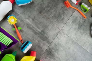 Sonbahar temizliği. Renkli şişeler, yapışkan sıvılar ve gri fayansların üzerindeki renkli temizlik seti..