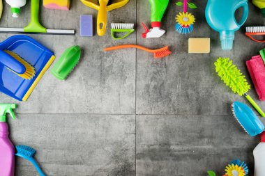 Sonbahar temizliği. Renkli şişeler, yapışkan sıvılar ve gri fayansların üzerindeki renkli temizlik seti..