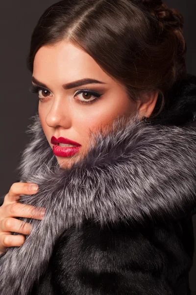 Een mooie jonge vrouw gekleed in een winterjas — Stockfoto