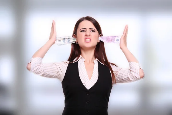 Angry business woman holding money in the ears — Stock Photo, Image