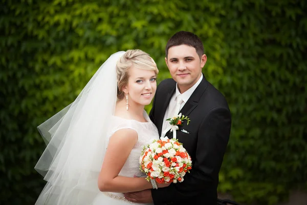 Sposi felici in un parco il giorno del loro matrimonio — Foto Stock