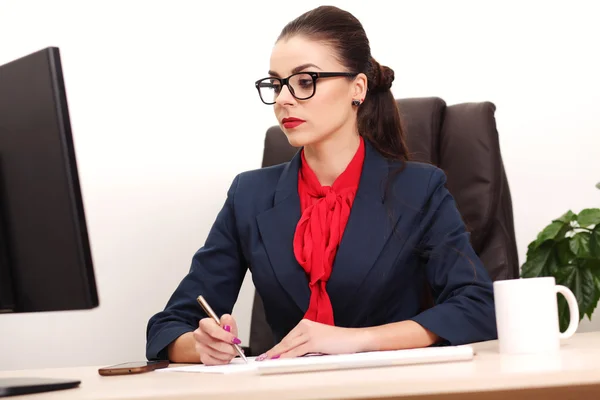 Porträt einer Geschäftsfrau mit Laptop schreibt auf ein Dokument in ihrem Büro — Stockfoto