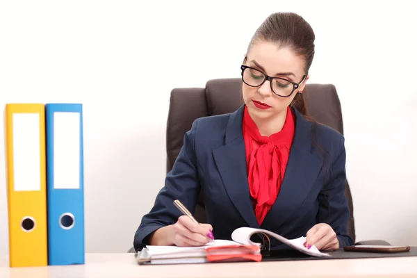 Porträtt av affärskvinna med bärbar dator skriver på ett dokument på sitt kontor — Stockfoto