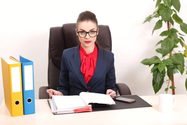 Portrait de femme d'affaires avec ordinateur portable écrit sur un document à son bureau — Photo