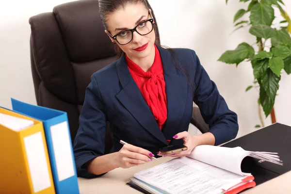 Portrait de femme d'affaires avec ordinateur portable écrit sur un document à son bureau — Photo