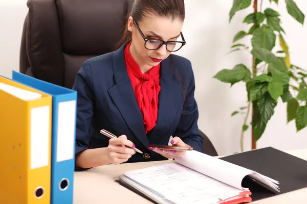 Retrato de mujer de negocios con portátil escribe en un documento en su oficina — Foto de Stock